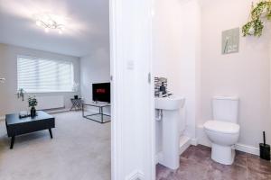 海伍德Lovely three bed home Manchester的白色的浴室设有卫生间和水槽。