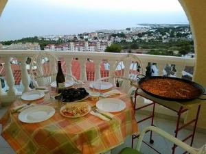 阿尔考斯布里Chalet en Alcossebre的餐桌,带食物盘和一瓶葡萄酒