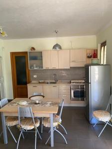 马蒂纳塔Casa Vacanze Rinaldi的厨房配有桌椅和冰箱。