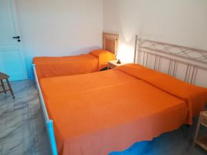 圣凯撒利亚温泉Le Querce Santa Cesarea Terme的配有橙色床单的客房内的两张床