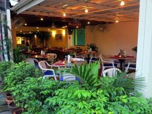 卡伦海滩天堂客栈的一间设有桌椅的餐厅,种植了植物