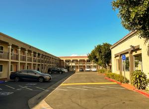 南门Rodeway Inn South Gate - Los Angeles South的停在大楼前停车场的汽车