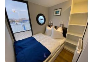 巴特Hausboot Fjord Vela mit Biosauna in Barth的一间小卧室,配有床和窗户