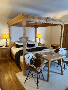 泰根塞路易特鲍尔德海滨酒店的一间卧室配有天蓬床和桌椅
