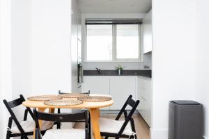 伦敦Modern Brixton Apartment的一个带木桌和椅子的小厨房