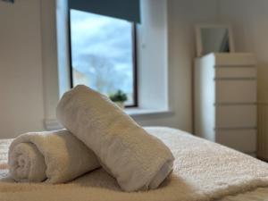 SpittalBeach House in Berwick Upon Tweed - 2 Double Bedrooms的床上的毛巾,带窗户