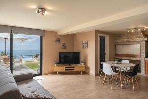 Madalena do MarOurMadeira - OceanScape, tranquil的客厅配有电视和桌椅
