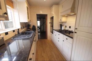 切森特3bedroom beautiful cottage的厨房配有白色橱柜和水槽