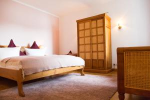 泰根塞路易特鲍尔德海滨酒店的一间卧室配有一张床和一个木制橱柜