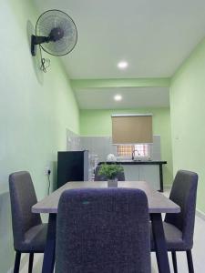 日得拉Sri Aman Homestay的客房配有桌椅和风扇。
