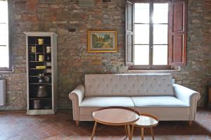 佛罗伦萨Podere di Montecchio - Colleramole的客厅配有沙发和2张桌子