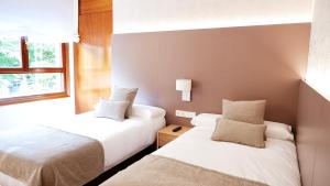 杜兰戈Hotel Ocamiño的酒店客房设有两张床和窗户。