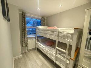 Hackbridge2a Seymour Road的小房间设有一张双层床和窗户