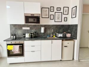 布达佩斯MM D Home Apartment的厨房配有白色橱柜和台面