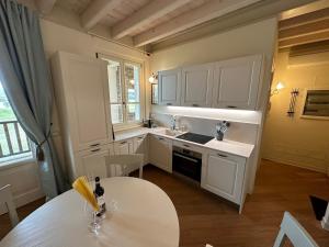 波佐伦戈Green Living Apartment的厨房配有白色橱柜和桌子