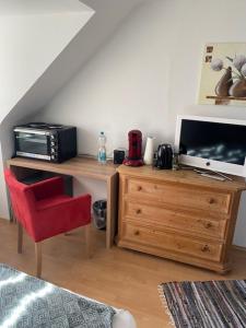 杜塞尔多夫里昂公寓的客房设有书桌、电视和红色椅子