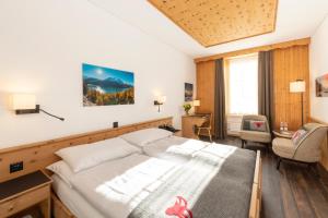 锡尔斯玛丽亚雪绒花瑞士品质酒店的配有一张床和一把椅子的酒店客房