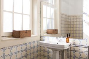 波尔图Alameda Suites - River Guest House的一间带水槽和镜子的浴室