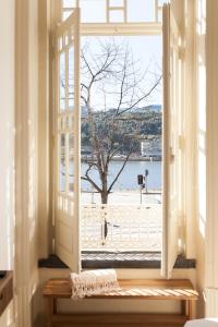 波尔图Alameda Suites - River Guest House的享有海滩景致的开放式窗户