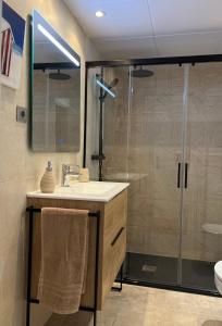 滨海阿雷尼斯Musclera的一间带水槽和玻璃淋浴的浴室