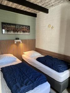 辛佩尔费尔德Vakantiebungalow nr 7 in het Heuvelland的墙上的房间里设有两张床