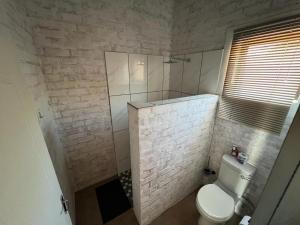 Kamanjab考克布什旅馆的浴室配有白色卫生间和淋浴。