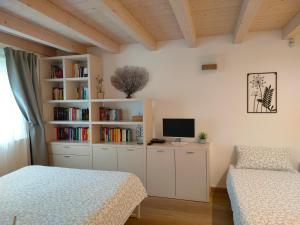 的里雅斯特Casa Vacanze Barcola的一间卧室设有两张床和书架