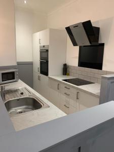 邓迪DS Study or Visit的白色的厨房配有水槽和微波炉