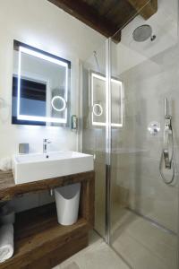 博尔索-德尔格拉帕阿蒂卡阿芭佳酒店的一间带水槽和玻璃淋浴的浴室