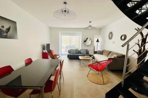 拉罗谢尔Le Cordouan的客厅配有桌子和红色椅子