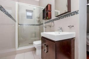 鲁德普特Paradise Guest House的一间带水槽、淋浴和卫生间的浴室