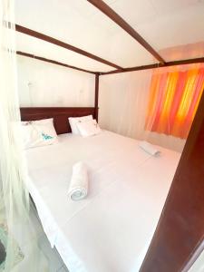 坦加拉Sanderling Silent Beach Cabanas的一张白色的床,上面有一条可移动的毛巾
