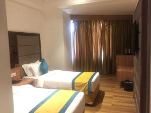 瓦拉纳西Arcadia Hotel的酒店客房设有两张床和窗户。