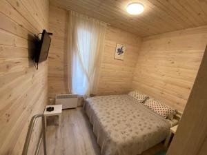 KriukivshchynaЗатишний будинок в передмісті Києва的卧室配有木墙内的一张床