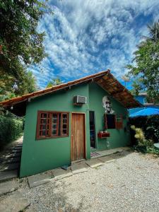 阿布拉奥Mambembe Hostel - Ilha Grande的一座小绿色房子,侧面有一张脸