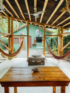 阿布拉奥Mambembe Hostel - Ilha Grande的客房设有吊床和桌子。