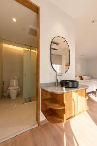 曼谷Boxpackers Pratunam的浴室设有水槽和镜子,位于柜台上