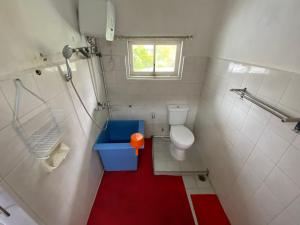 不拉士打宜Villa Berastagi Indah A17 - TEBU MANIS的一间铺有红色地板的小浴室,设有卫生间