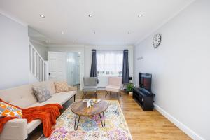 巴尔金Newly refurbished charming 3-Bed House in Barking的客厅配有沙发和桌子
