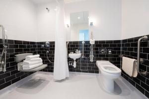 布罗德斯泰Yarrow Hotel的黑色瓷砖浴室设有卫生间和水槽