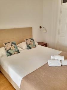里斯本阿尔法玛服务公寓的一间卧室配有两张大床和枕头