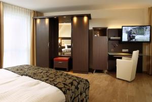 沃尔夫斯堡Hotel Simonshof的酒店客房配有一张床、一张书桌和一台电视。