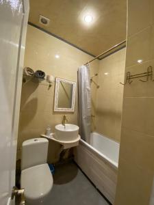 哈尔科夫Міні готель на Костюринському的浴室配有卫生间、盥洗盆和浴缸。
