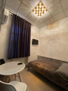 哈尔科夫Міні готель на Костюринському的卧室配有1张床、1张桌子和1张桌子以及椅子。