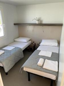 伊穆尼Mobilna kućica Val的一间设有两张床铺和毛巾的房间