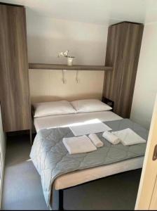 伊穆尼Mobilna kućica Val的一间卧室配有一张床,上面有两条毛巾