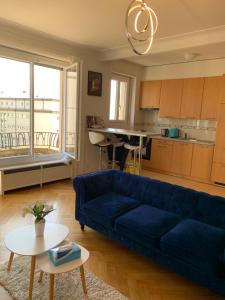 洛桑City appartement的一间带蓝色沙发的客厅和一间厨房