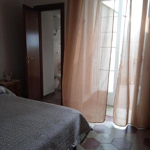 Santa PaolinaCasa di Paola a Tufo的一间卧室配有床和带窗帘的窗户