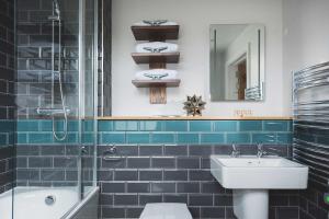 福伊Havener's的蓝色瓷砖浴室设有水槽和淋浴