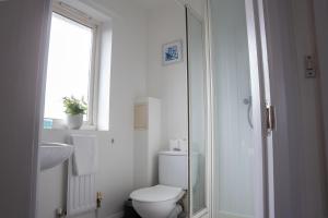 米尔顿凯恩斯Comfortable 4 Bedroom Home in Milton Keynes by HP Accommodation with Free Parking, WiFi & Sky TV的一间带卫生间、水槽和窗户的浴室